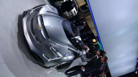 1993 Ford Taurus - A futuristic silver Chevrolet concept car is displayed at an auto show, drawing attention from onlookers.