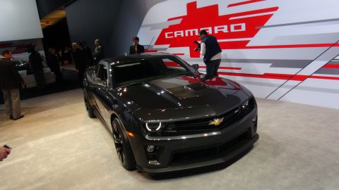 1993 Ford Taurus - A dark gray Chevrolet Camaro is displayed at an auto show, with the word 'CAMARO' visible on the wall.