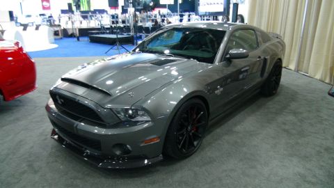 1993 Ford Taurus - A gray 2010 Shelby GT500 coupe is displayed indoors next to a red vehicle.