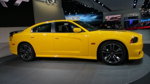 1993 Ford Taurus - A bright yellow Dodge Charger is displayed at an auto show, its side profile and sporty details.