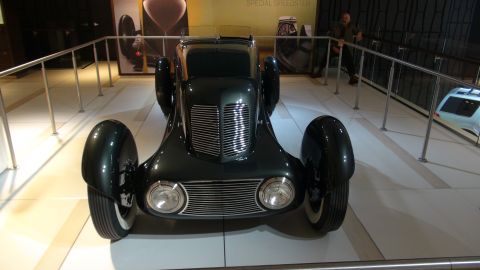 1993 Ford Taurus - A classic speedster is displayed indoors, behind a railing, with a person visible in the background.