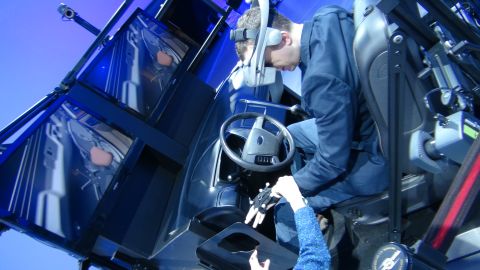 1993 Ford Taurus - A person uses a vehicle simulator, which mimics the interior of a car, complete with a steering wheel and seats.