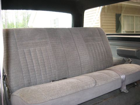 1988 Ford Bronco - The rear bench seat of a vehicle is shown, with a seatbelt buckled across it.