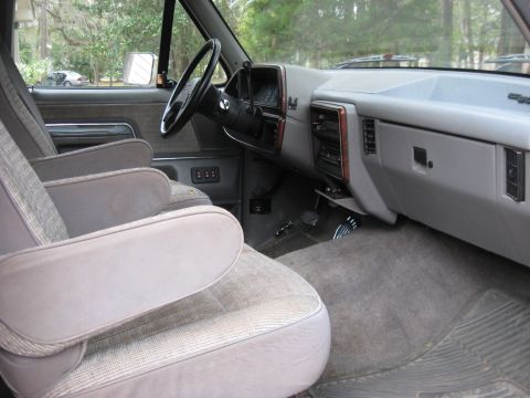 1988 Ford Bronco - The interior of a 1987 Ford Bronco shows its cloth seats and dashboard.