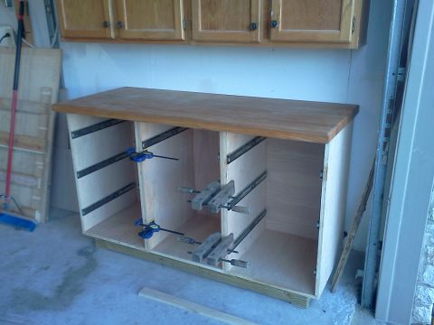 1996 Ford Bronco - Workbench construction in progress, showing drawer slides and clamps, with overhead cabinets visible.