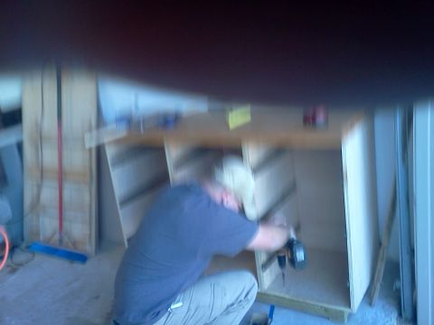 1996 Ford Bronco - A person is actively working on constructing wooden shelves in a workshop environment.
