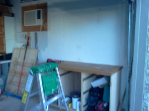 1996 Ford Bronco - A garage scene shows a workbench, a ladder, and an air conditioning unit mounted on the wall.
