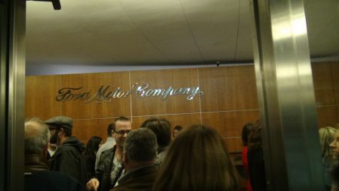 1993 Ford Taurus - A group of people stand before the Ford Motor Company sign inside a building.