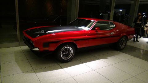 1993 Ford Taurus - A red 1971 Ford Mustang Mach 1 is displayed indoors with a black hood and side stripe.