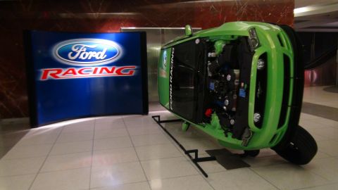 1993 Ford Taurus - A green Ford Mustang is displayed with its engine visible, alongside a Ford Racing banner.