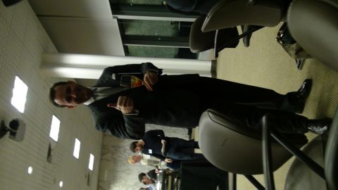 1993 Ford Taurus - Man in a suit holding a drink and gesturing in a conference room setting.