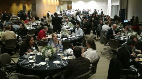 1993 Ford Taurus - A large group of people are attending a formal dinner event, with tables set for a meal.