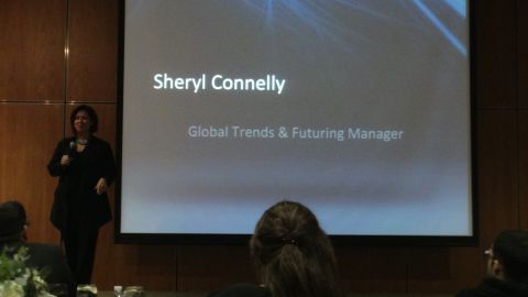 1993 Ford Taurus - A speaker presents information on a large screen that displays her name and title, 'Sheryl Connelly, Global Trends & Futuring Manager'.