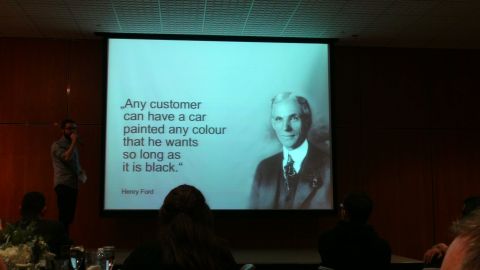 1993 Ford Taurus - A speaker presents a slide a quote from Henry Ford and his portrait to an audience.