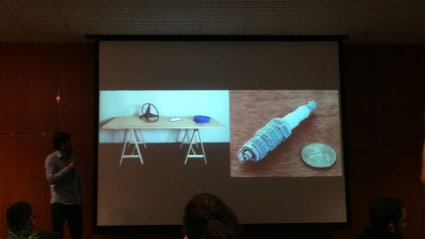 1993 Ford Taurus - A presentation displays a spark plug next to a coin and a steering wheel on a table.