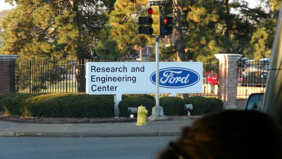 Sign for Ford Research and Engineering Center with a traffic light and trees
