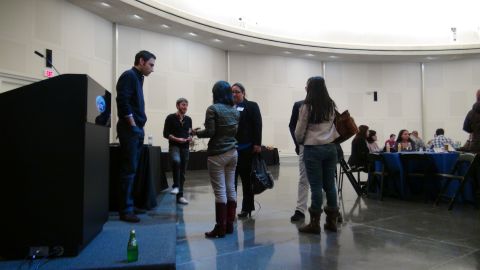 1993 Ford Taurus - Attendees converse near a podium and seated tables during an event.