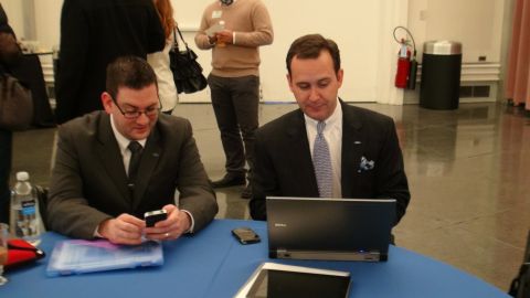 1993 Ford Taurus - Men in suits engage with technology at a table during an event.