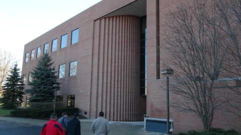 1993 Ford Taurus - People walk past a large brick building with modern architectural elements on a clear day.