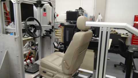 1993 Ford Taurus - A car interior simulator setup is shown with a beige seat and steering wheel.