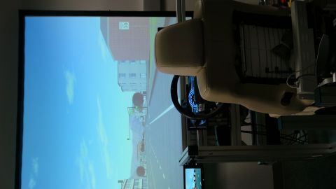 1993 Ford Taurus - Interior view of a driving simulator a steering wheel and a projected road scene.