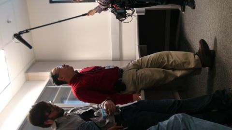 1993 Ford Taurus - A film crew records a conversation between two men in an office environment.