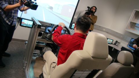 1993 Ford Taurus - A driving simulator setup is being filmed by two cameramen.