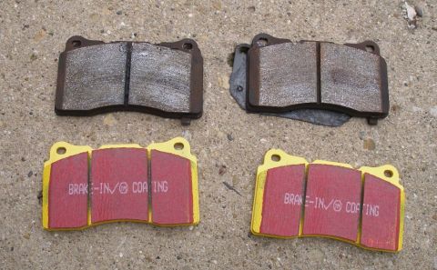 2010 Hyundai Genesis - New and used brake pads shown on a concrete surface.