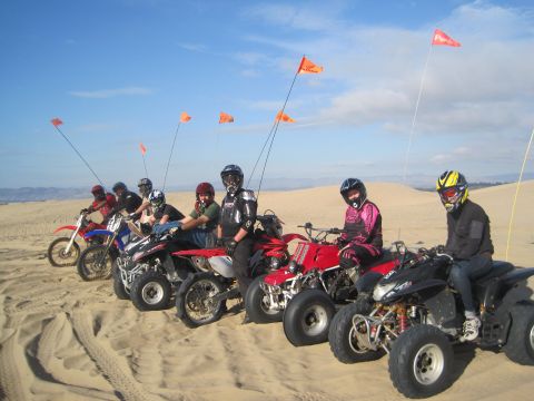 1968 Ford Bronco - A group of off-road vehicles and their riders are gathered on sandy terrain.