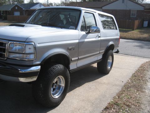 1994 Ford Bronco - This Ford Bronco is shown from the front quarter angle, highlighting its two-tone paint and lifted stance.