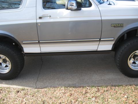 1994 Ford Bronco - The side profile of a 1994 Ford Bronco, identifiable by its distinct body style and fender badging.