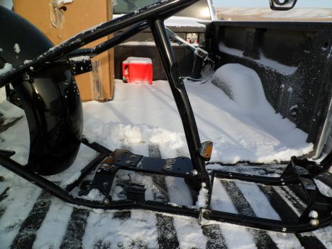 1973 Harley-Davidson Ultra - A motorcycle frame and fender are loaded into the bed of a truck, which is covered in snow.