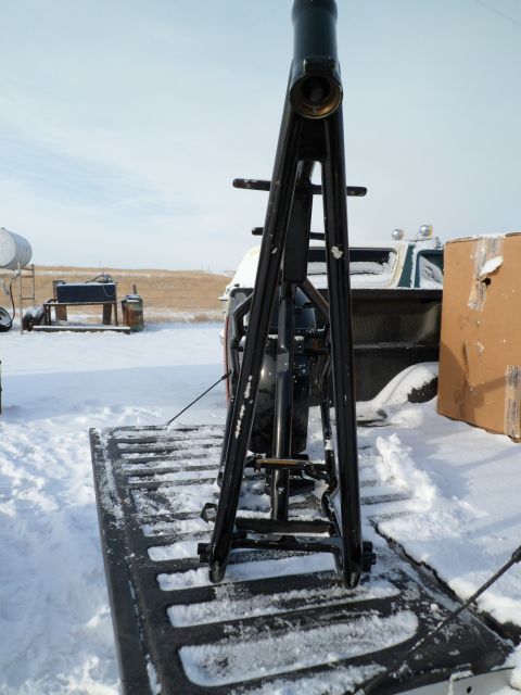1973 Harley-Davidson Ultra - A black motorcycle frame is loaded onto a pickup truck bed, with snow covering the ground and the truck.