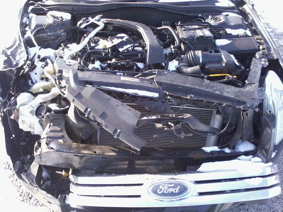 Front-end collision damage to a Ford vehicle engine bay
