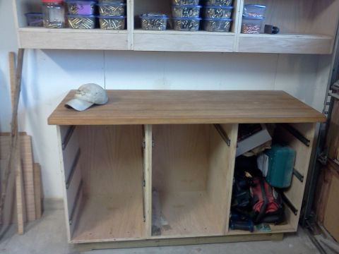 1996 Ford Bronco - A workbench with open storage below and shelves filled with ammunition containers above.
