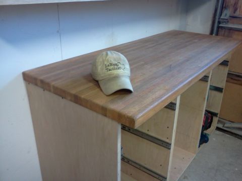 1996 Ford Bronco - A workbench with a baseball cap sits in a garage setting.