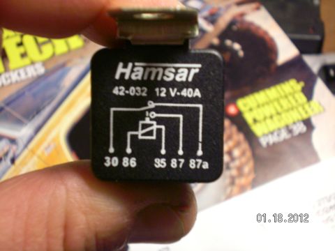 1996 Ford Bronco - A Hamsar automotive relay is held by a finger, with a magazine visible in the background.
