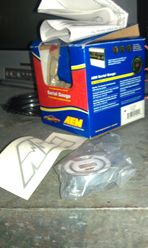 1995 Honda Civic - An AEM Serial Gauge box and its contents are shown on a textured surface.