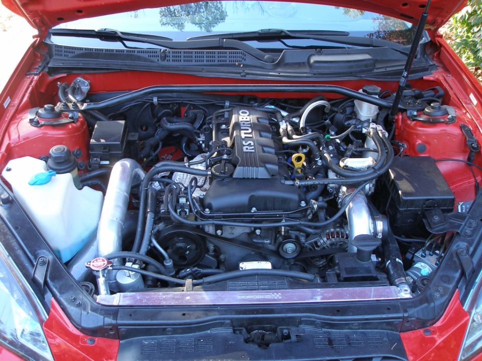 Red Hyundai Genesis Coupe engine bay with RS TURBO engine cover.