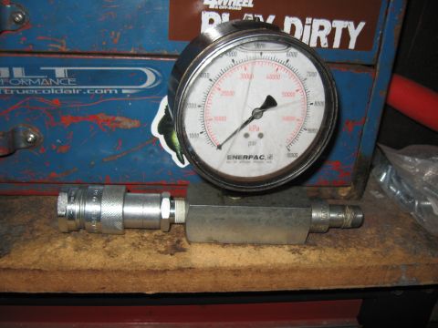 1994 Ford Bronco - Hydraulic pressure gauge and fitting assembly on a workbench.