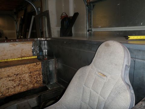1961 International Scout 800 - The interior of a vehicle shows a bucket seat and unfinished metalwork, with a measuring tape visible.