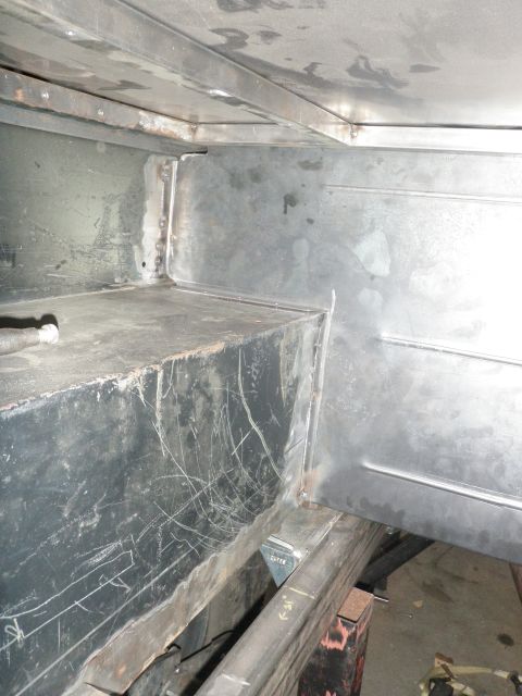 1961 International Scout 800 - The interior of a vehicle shows unfinished metalwork and a large, scratched black storage container.