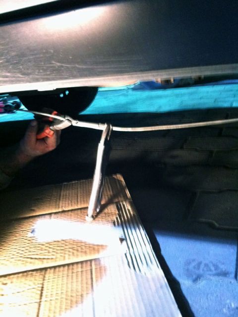 2001 Mercury Grand Marquis - Working on the brake cable under the vehicle's chassis.