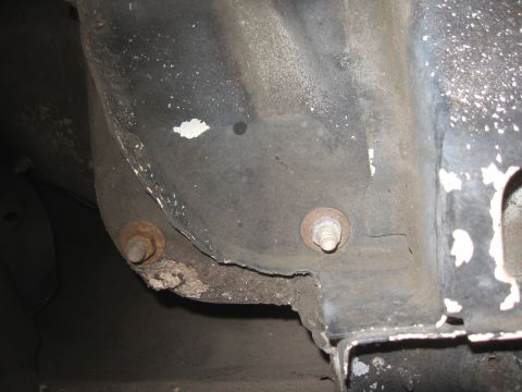 1994 Ford Bronco - The frame of a vehicle shows significant rust and corrosion around mounting points.