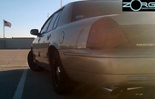 2000 Mercury Grand Marquis - A gold Mercury Grand Marquis is seen from the rear quarter angle under a clear sky.