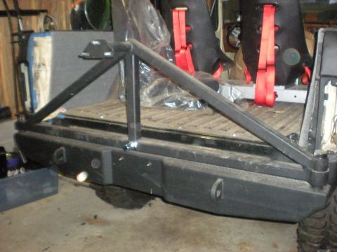 1978 Ford Bronco - Rear view of a vehicle's bumper and interior, showing a roll cage and racing seats.