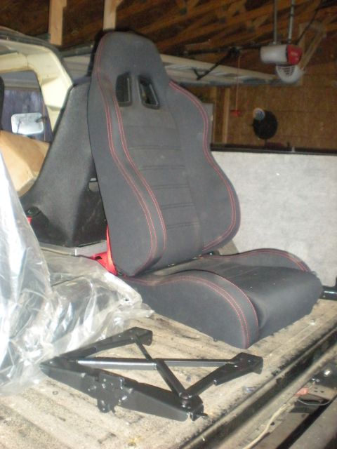 1978 Ford Bronco - A racing seat and a scissor jack are visible in the bed of a truck.