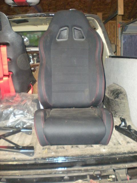 1978 Ford Bronco - Aftermarket racing seats with red stitching are installed in the cargo area of a vehicle.