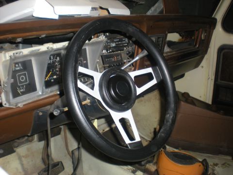 1978 Ford Bronco - Interior view of a vehicle, showing an aftermarket steering wheel and dashboard gauges.