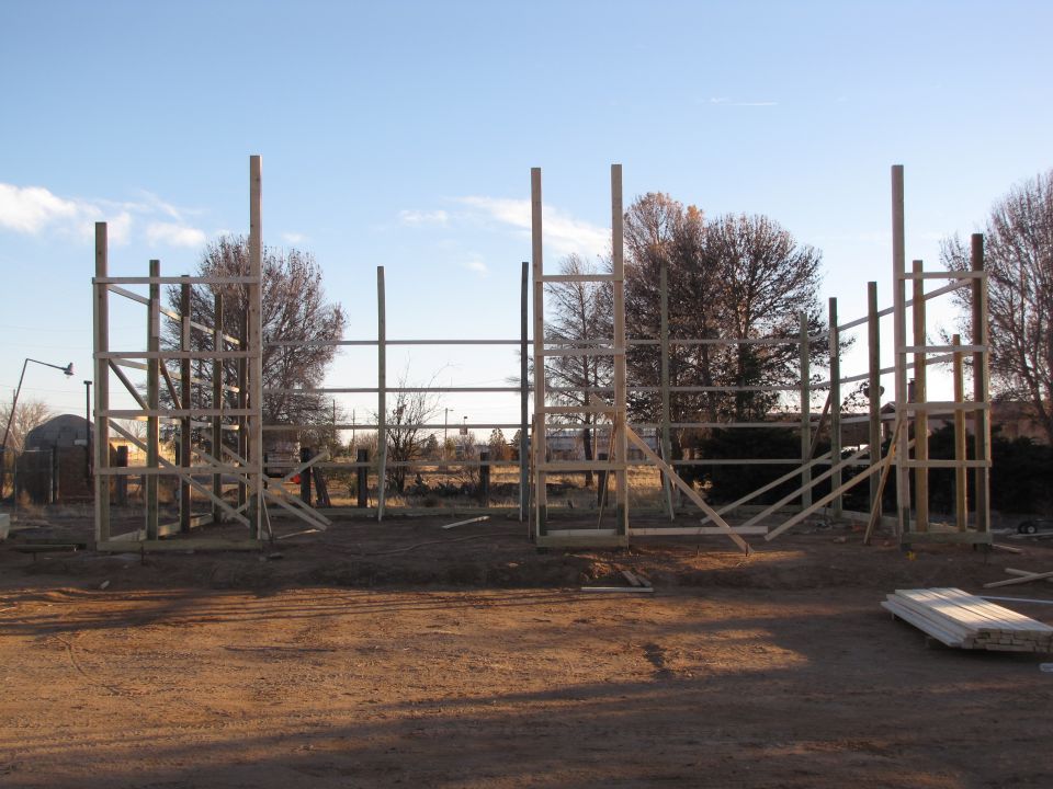 Wooden frame of a building under construction against a blue sky.